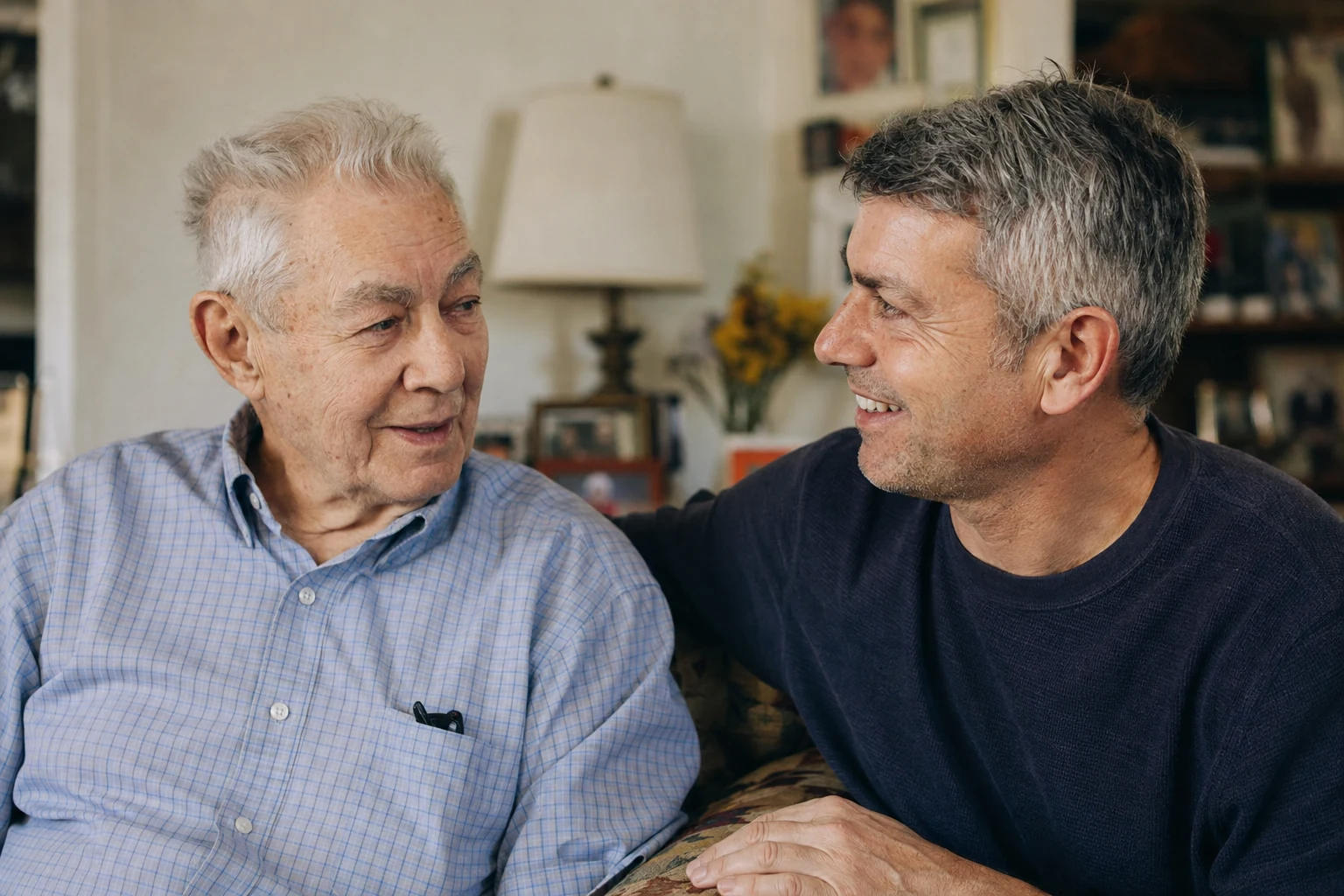 An older father and his adult son sharing a relaxed moment at home